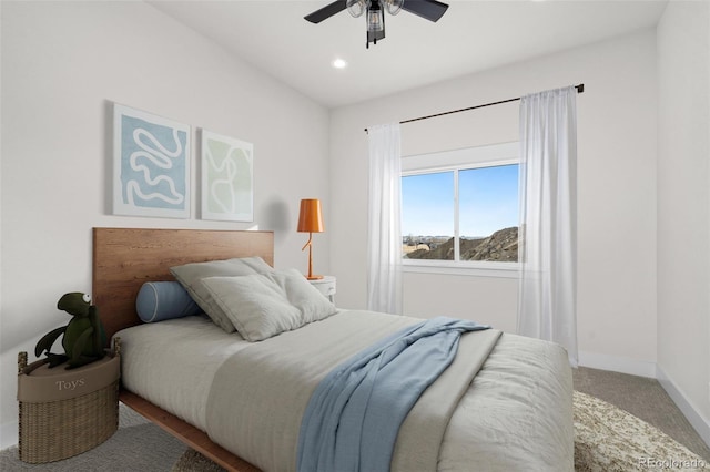 carpeted bedroom with ceiling fan and a mountain view