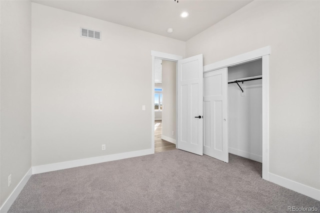 unfurnished bedroom featuring light carpet and a closet