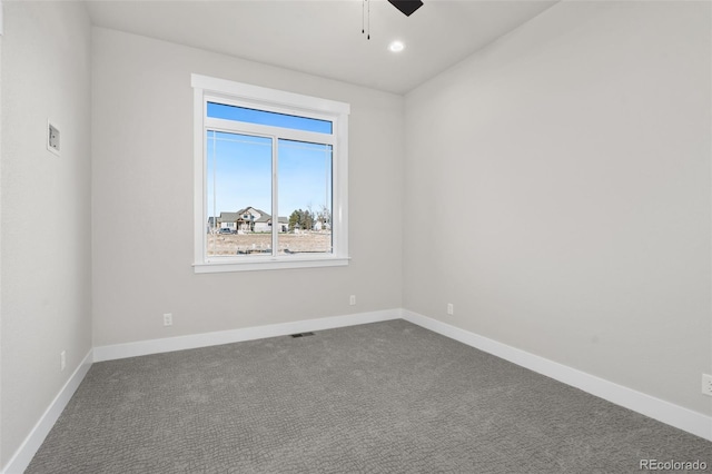 carpeted spare room featuring ceiling fan