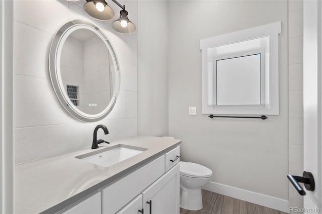 bathroom featuring vanity, decorative backsplash, wood-type flooring, and toilet