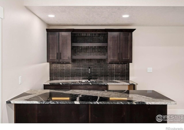 kitchen featuring sink, dark brown cabinets, and backsplash