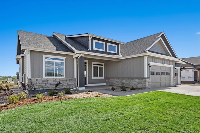 1369 Burt Ave, Berthoud, CO 80513 - view of front of property featuring stone siding, concrete driveway, an attached garage, a front lawn, and board and batten siding