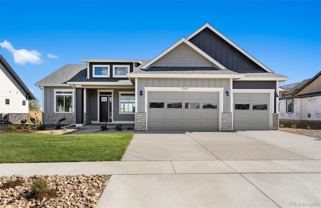 1369 Burt Ave, Berthoud, CO 80513 - view of front of house featuring board and batten siding, concrete driveway, a shingled roof, an attached garage, and stone siding