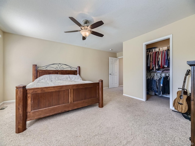 bedroom with ceiling fan, a textured ceiling, a closet, and light carpet