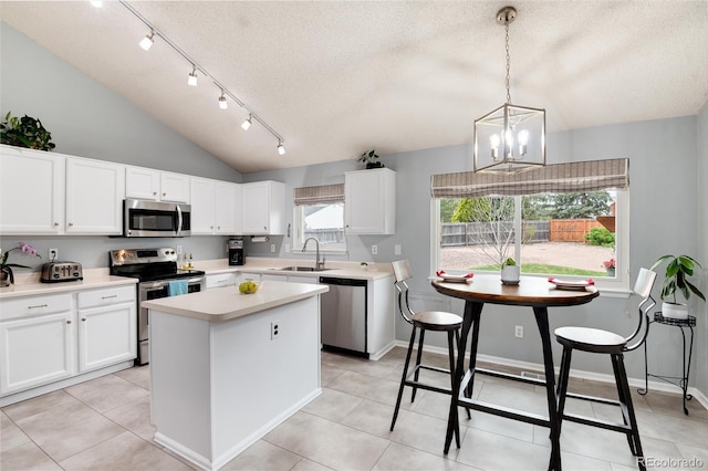 kitchen featuring light countertops, stainless steel appliances, a textured ceiling, and a sink