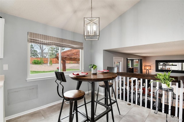 dining room featuring an inviting chandelier, a textured ceiling, and light tile patterned flooring