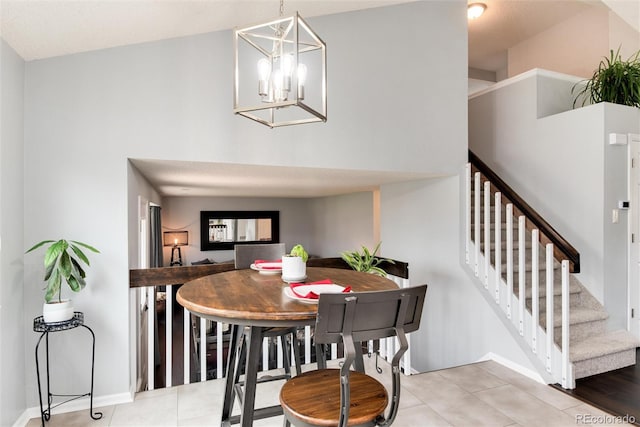 dining area featuring an inviting chandelier, baseboards, light tile patterned floors, and stairs