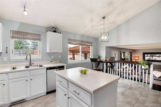 kitchen featuring light countertops, white cabinetry, a sink, and dishwasher