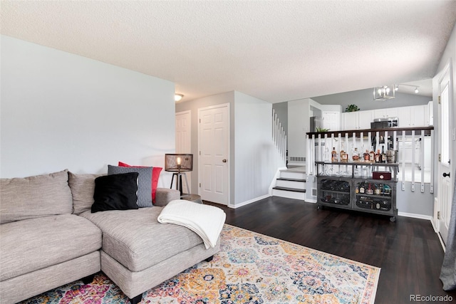 living room featuring a textured ceiling, a chandelier, baseboards, dark wood-type flooring, and stairway