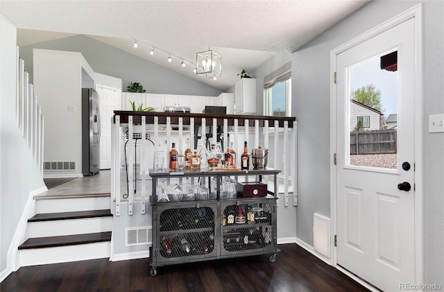 bar featuring an inviting chandelier, visible vents, wood finished floors, stainless steel fridge, and stairs