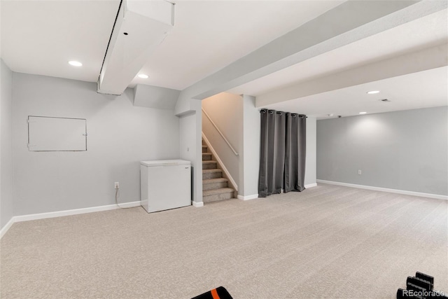 finished below grade area with baseboards, recessed lighting, light carpet, and refrigerator