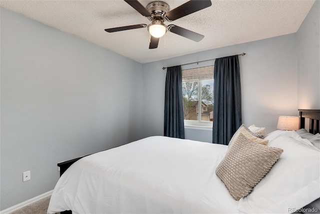bedroom with baseboards, a textured ceiling, carpet, and a ceiling fan