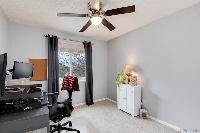 carpeted office space with baseboards and a ceiling fan