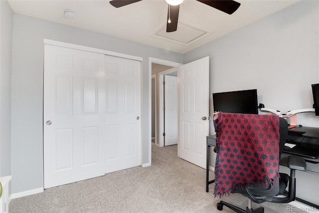 office space featuring baseboards, light carpet, and a ceiling fan