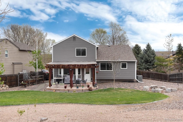 rear view of property with a shingled roof, a fenced backyard, central AC unit, a lawn, and a patio