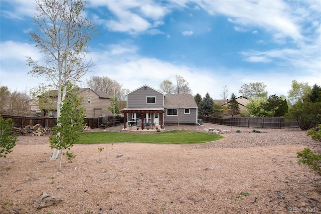 back of house featuring a lawn, a fenced backyard, and a patio area