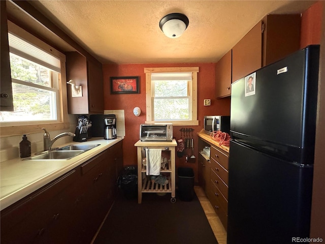 582 Pactolus Lake Rd, Black Hawk, CO 80422 - kitchen with freestanding refrigerator, light countertops, healthy amount of natural light, stainless steel microwave, and a textured ceiling