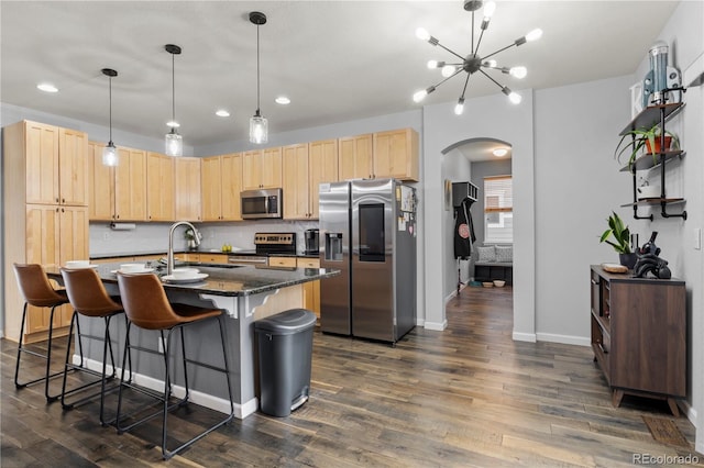 kitchen featuring a kitchen island with sink, sink, light brown cabinetry, dark hardwood / wood-style flooring, and stainless steel appliances