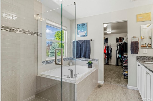 bathroom with separate shower and tub and vanity