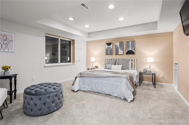 carpeted bedroom with a tray ceiling