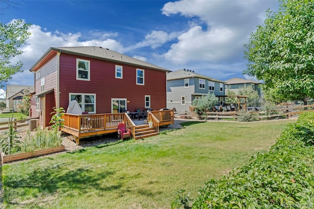 back of property with a lawn and a wooden deck