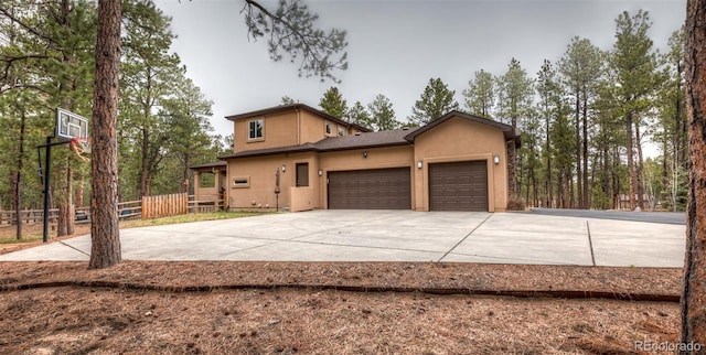 15948 Huckleberry Hts, Colorado Springs, CO 80908 - view of property exterior with stucco siding, a garage, fence, and concrete driveway