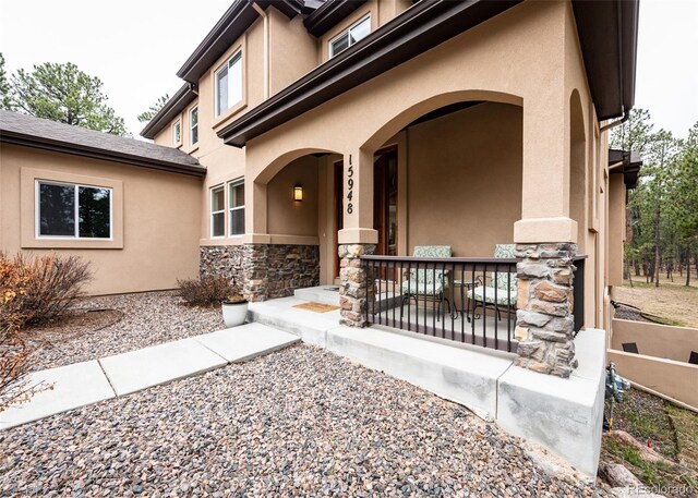 15948 Huckleberry Hts, Colorado Springs, CO 80908 - entrance to property with stucco siding, a porch, and stone siding