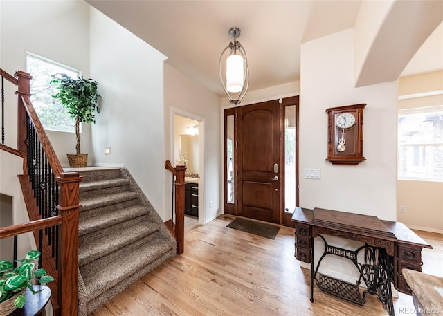 15948 Huckleberry Hts, Colorado Springs, CO 80908 - entrance foyer featuring baseboards, light wood finished floors, a healthy amount of sunlight, and stairway
