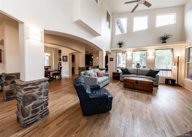 15948 Huckleberry Hts, Colorado Springs, CO 80908 - living room featuring plenty of natural light, arched walkways, ceiling fan with notable chandelier, and wood finished floors