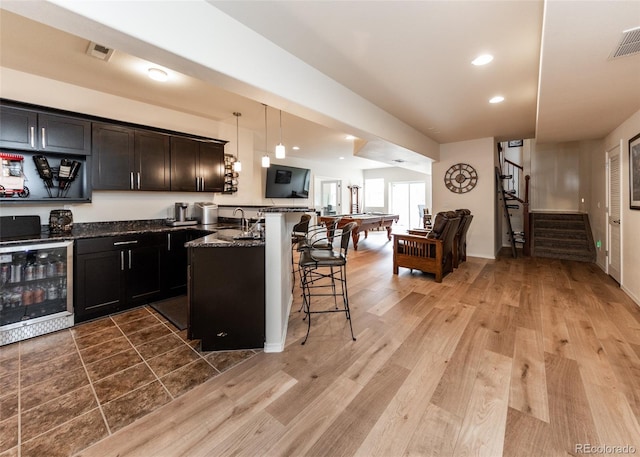 15948 Huckleberry Hts, Colorado Springs, CO 80908 - kitchen featuring a breakfast bar, a sink, beverage cooler, a peninsula, and visible vents