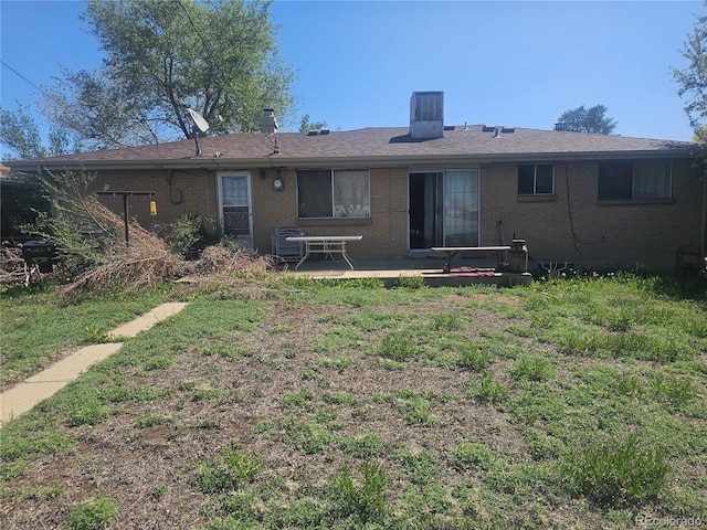 back of house with a patio and brick siding