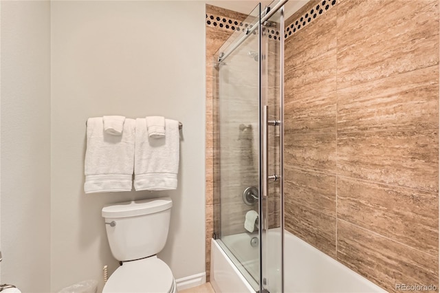 bathroom featuring toilet and bath / shower combo with glass door