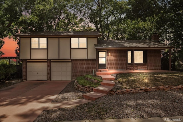 4631 Ashfield Dr, Boulder, CO 80301 - view of front of property featuring brick siding, an attached garage, concrete driveway, a chimney, and a shingled roof