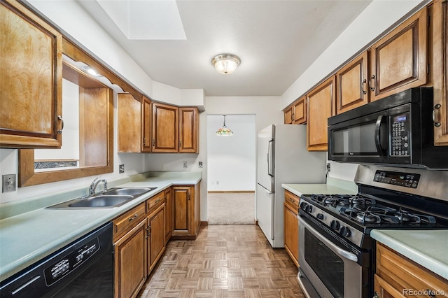 4631 Ashfield Dr, Boulder, CO 80301 - kitchen with black appliances, a skylight, brown cabinetry, and light countertops