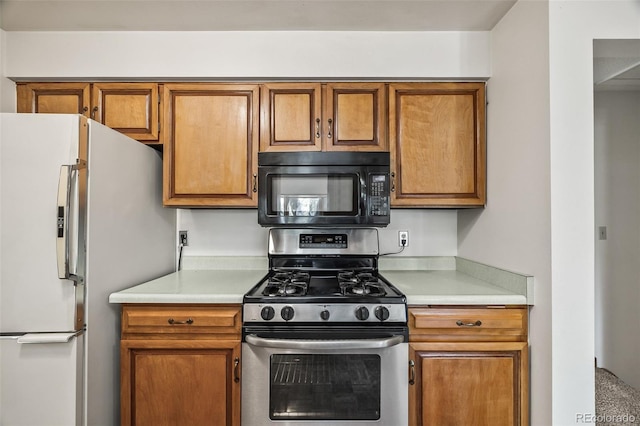 4631 Ashfield Dr, Boulder, CO 80301 - kitchen featuring black microwave, stainless steel range with gas stovetop, refrigerator with ice dispenser, brown cabinetry, and light countertops