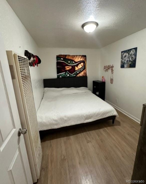 bedroom with hardwood / wood-style flooring and a textured ceiling