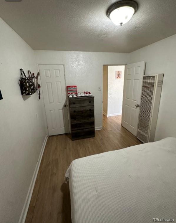 bedroom featuring a textured ceiling and hardwood / wood-style flooring