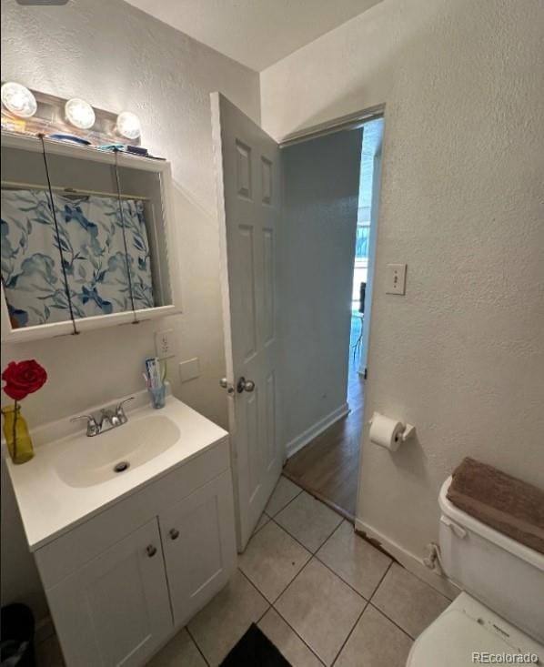 bathroom featuring tile flooring, toilet, and large vanity