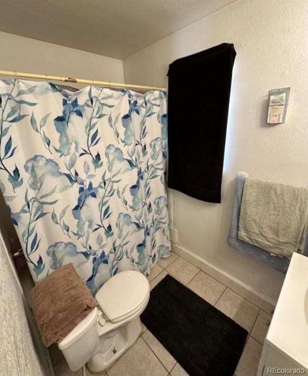 bathroom with tile flooring, vanity, and toilet