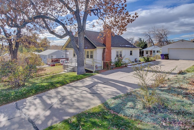 view of front of house with an outbuilding, a garage, and a front lawn