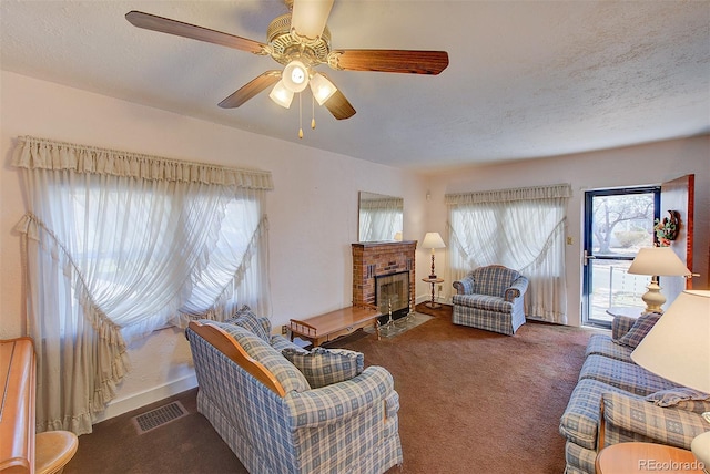 carpeted living room featuring ceiling fan, a textured ceiling, and a brick fireplace