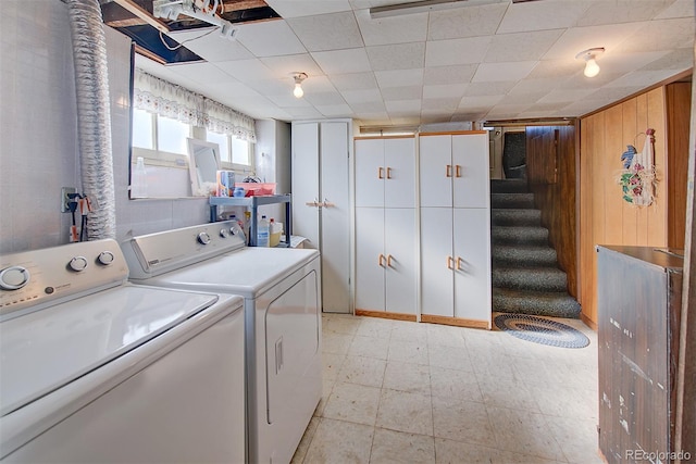 laundry area with wooden walls and washing machine and clothes dryer