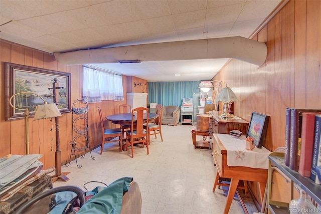 dining space featuring wood walls