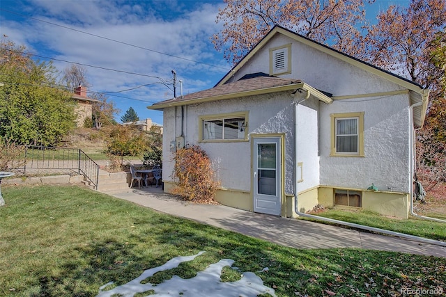 back of property featuring a lawn