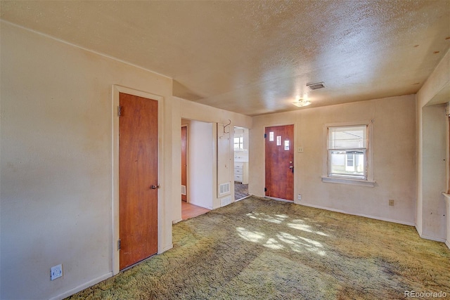 carpeted entrance foyer with a textured ceiling