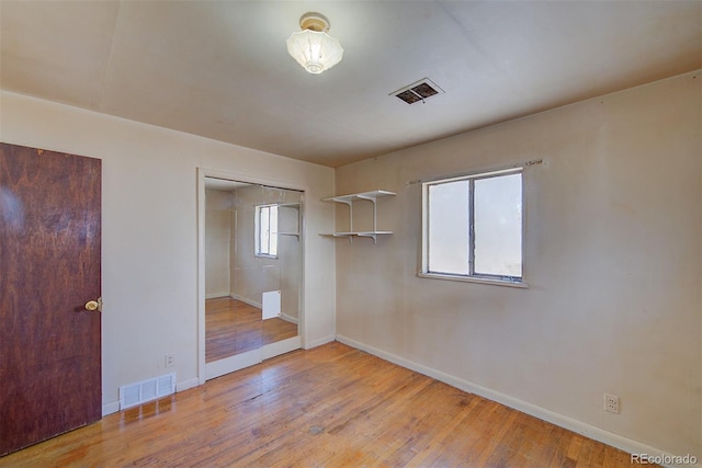 unfurnished bedroom featuring light hardwood / wood-style floors and a closet