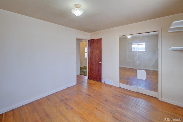 unfurnished bedroom with light hardwood / wood-style floors and a closet