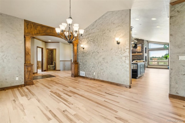 7830 Tannenbaum Rd, Colorado Springs, CO 80908 - unfurnished dining area with vaulted ceiling, light wood-type flooring, a chandelier, arched walkways, and baseboards