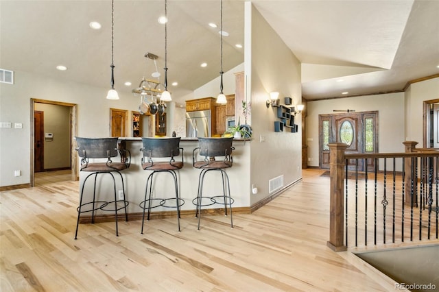 7830 Tannenbaum Rd, Colorado Springs, CO 80908 - kitchen with appliances with stainless steel finishes, light wood finished floors, lofted ceiling, baseboards, and a breakfast bar area