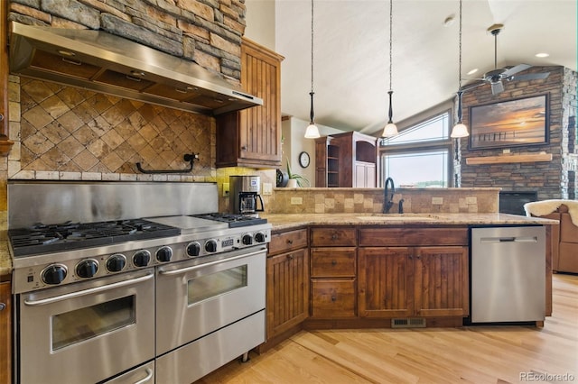 7830 Tannenbaum Rd, Colorado Springs, CO 80908 - kitchen with stainless steel appliances, exhaust hood, a sink, lofted ceiling, and light wood-style floors